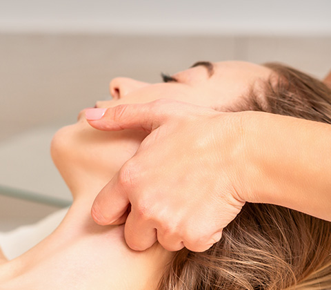 a beautician giving a woman a lymphatic drainage massage for a facelift 