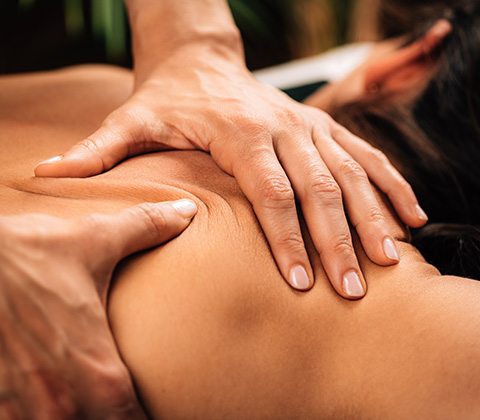 a beautician providing a deep tissue massage to a woman's back