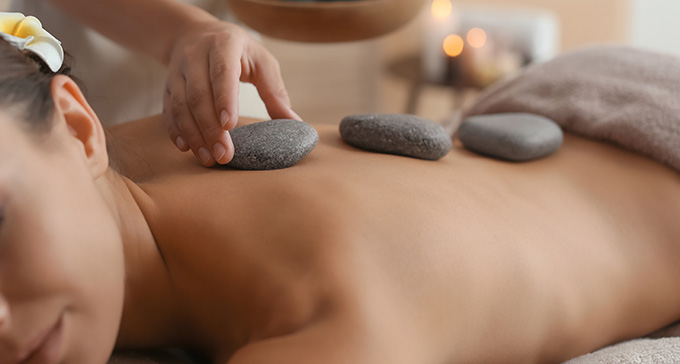a woman having a relaxing hot stone massage on her back